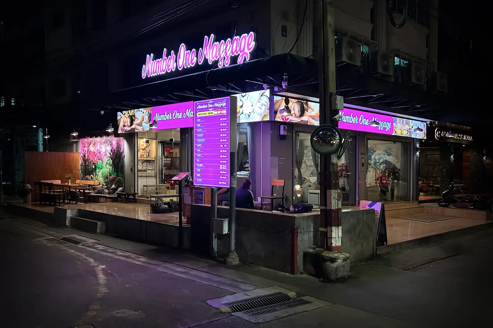 Number One Massage shopfront with its pink neon sign at night