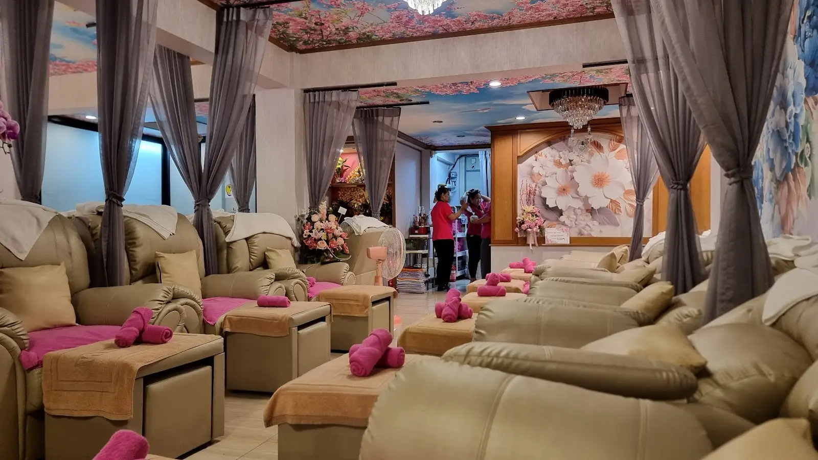 Foot massage lounge at Number One Massage with pink towels and a cherry-blossom ceiling